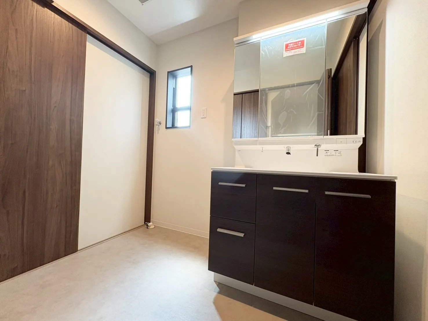 【洗面室】収納しやすい引き出しつきの洗面化粧台。照明をスリムにすることですっきりとした印象に。