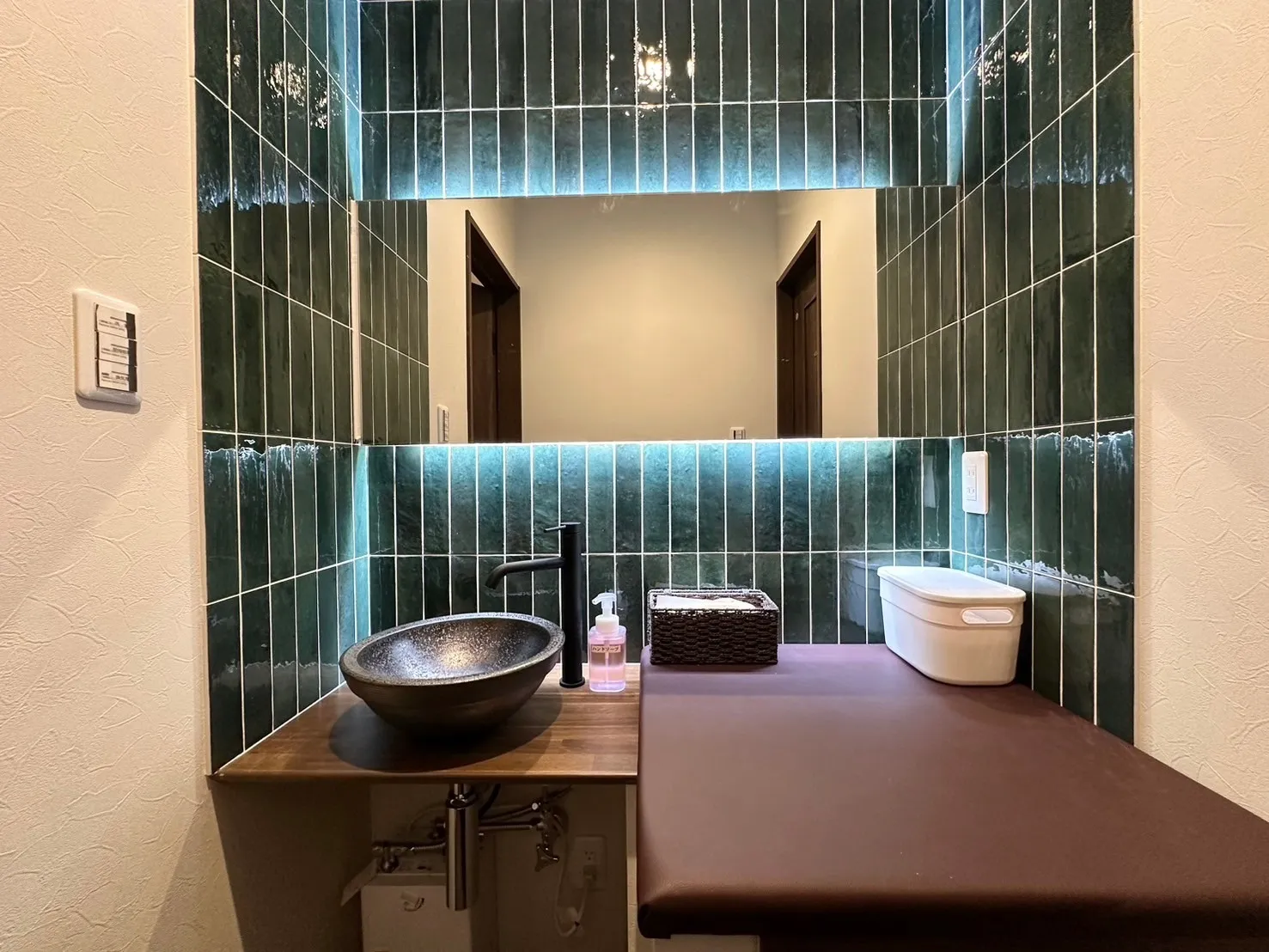 洗面室にはオシャレな緑のタイルを使用。間接照明の白照明は緑のタイルを美しく照らします。