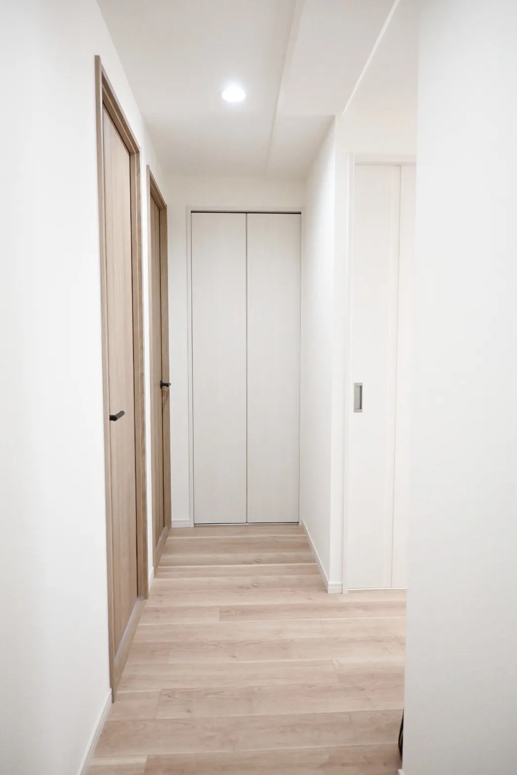 【廊下】扉を一部ホワイトカラーにすることで廊下を広く感じさせる効果がございます。