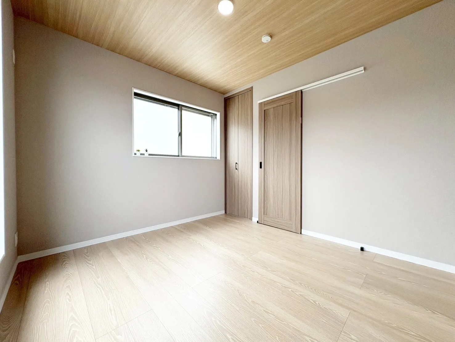 【洋室】木目の天井×グレーの壁クロスでホッと一息つけるやすらぎの空間に。